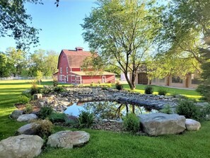 A red barn with a stone pond and large rocks in the foreground. - Romantic Rustic Luxury on 21-acre Private Ranch #3 (Silt)