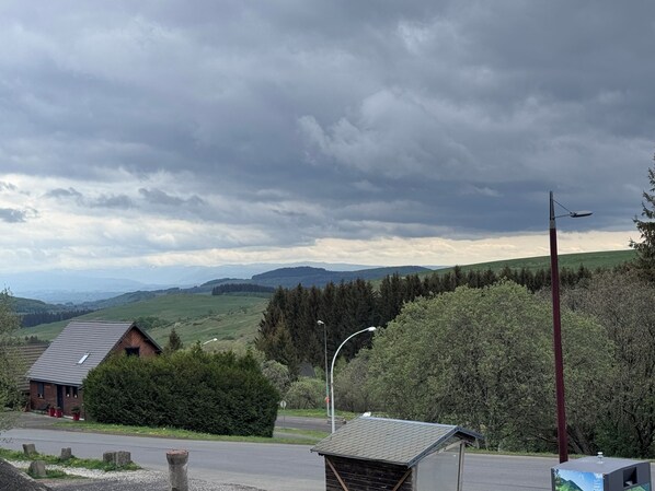 A rural landscape with a road, a small building, and a street lamp. - Studio 4-6 people in the heart of Super Besse near the slopes 4 seasons resort (Besse-et-Saint-Anastaise)