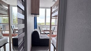 Una habitación con literas, una mesita pequeña y vistas al exterior.