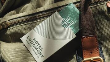 Una etiqueta con el texto 'HOTEL LONGMONT' y una vista parcial de un bolso con cremallera.