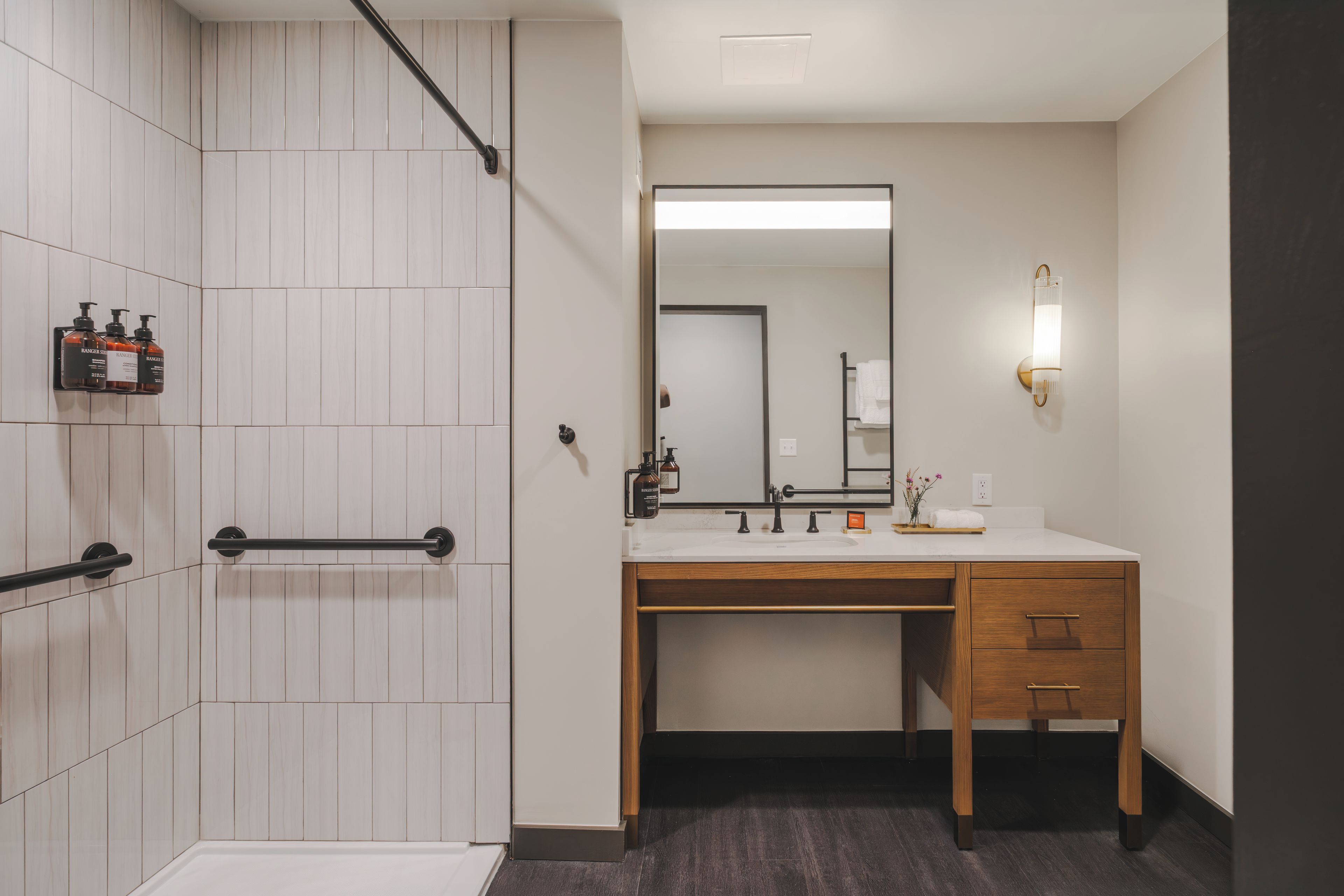 Une salle de bain moderne avec une douche, un lavabo et un miroir.