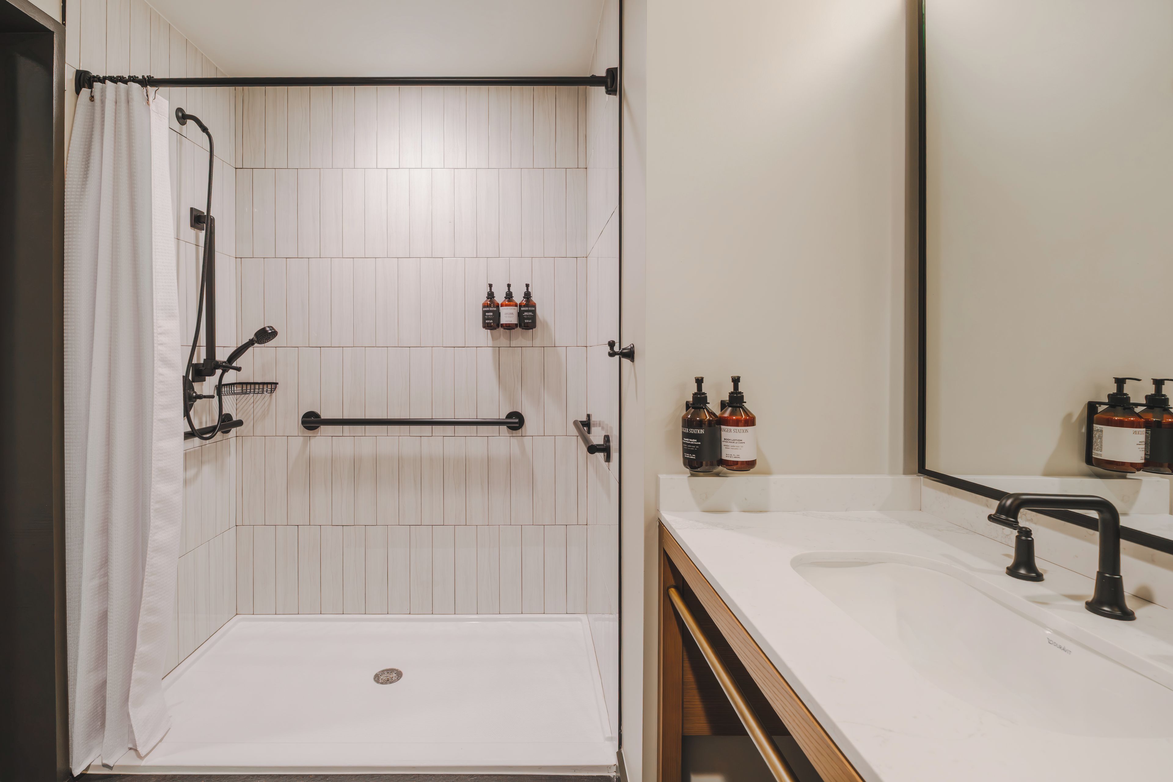 A modern bathroom with a shower, toilet, and sink.