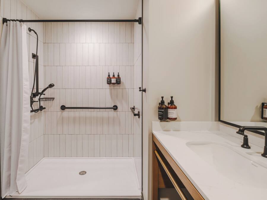 A modern bathroom with a shower, toilet, and sink.