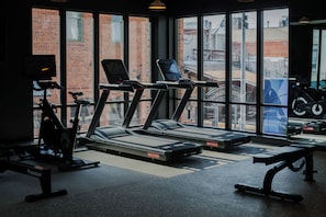 Un gimnasio con cintas de correr, bicicletas estáticas y equipo de ejercicio.