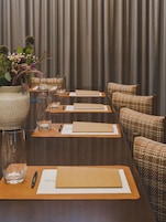 A conference room with a long table, chairs, and a decorative vase with flowers.