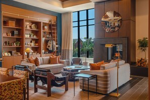 A modern living room with a fireplace, a sofa set, a coffee table, and a bookshelf.