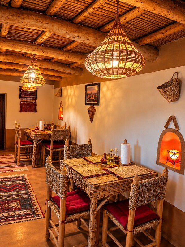 A rustic dining area with wicker furniture, woven tablecloths, and traditional decor.