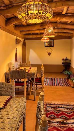 A traditional interior with woven furniture, a patterned rug, and a hanging light fixture. - DAR DANI café restaurant (Ait Sedrate Jbel El Soufla)