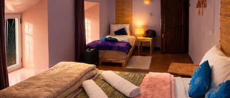 Une chambre à coucher avec un lit, une table de chevet, une lampe et une fenêtre.