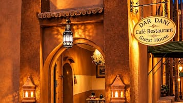 Entrada de um edifício tradicional marroquino, com uma placa indicando 'Dar Danni Café Restaurante Guest House'.