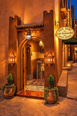 A traditional Moroccan building entrance with a sign for 'Dar Danni Café Restaurant Guest House.'