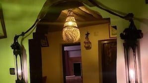 A hallway with a striped carpet, a chandelier, and wall-mounted lanterns. - DAR DANI café restaurant (Ait Sedrate Jbel El Soufla)