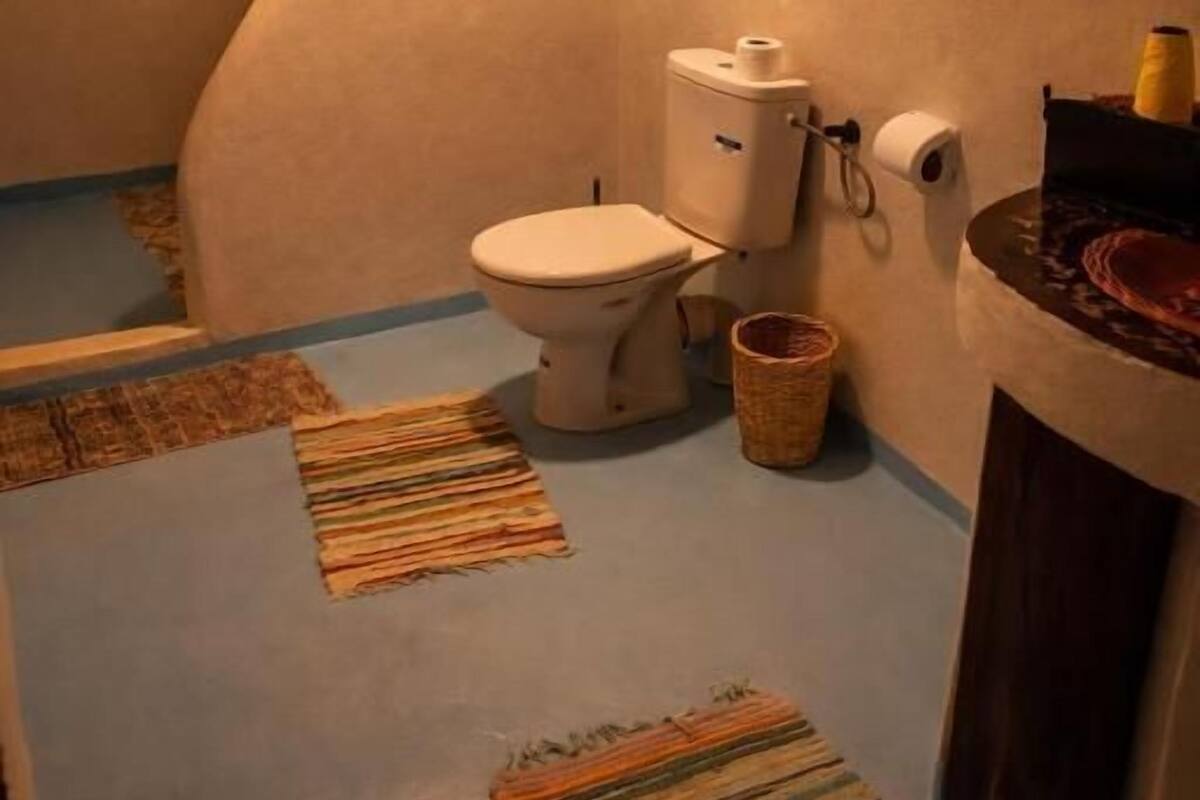 Un baño con inodoro, lavamanos y zona de ducha.