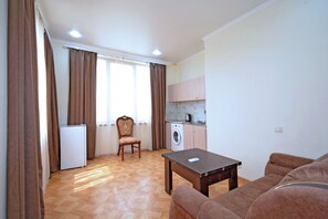 Deluxe-Apartment, Stadtblick | Wohnbereich | 75-cm-Flachbildfernseher mit Digitalempfang