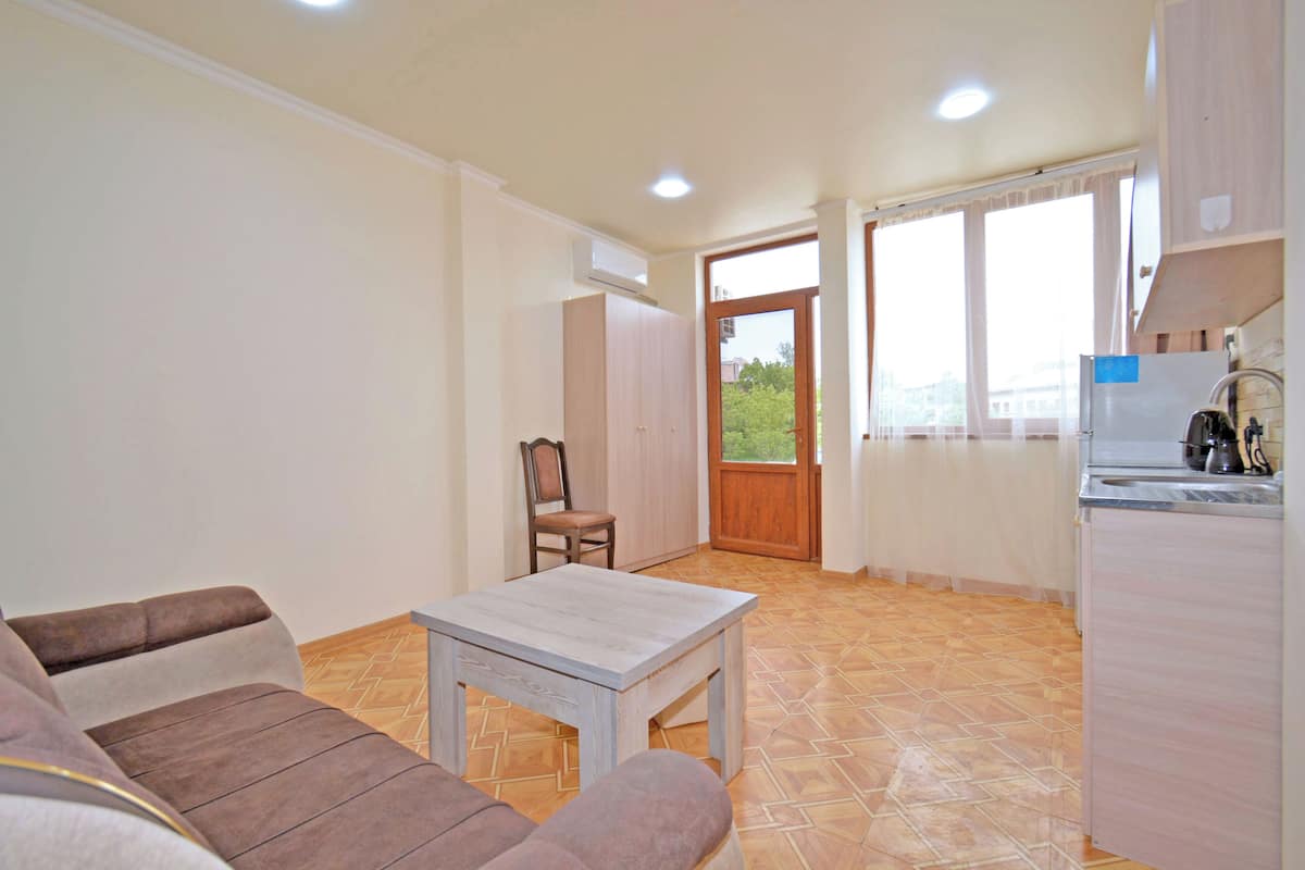 Family Apartment, City View | Living room | 75-cm flat-screen TV with digital channels, books