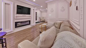 A living room with a fireplace, a television, and a sofa.