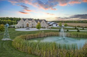 A large estate with a pond, a windmill, and a well-maintained lawn. - Castle On Malden - Luxury 50 Acre Private Estate (Essex)