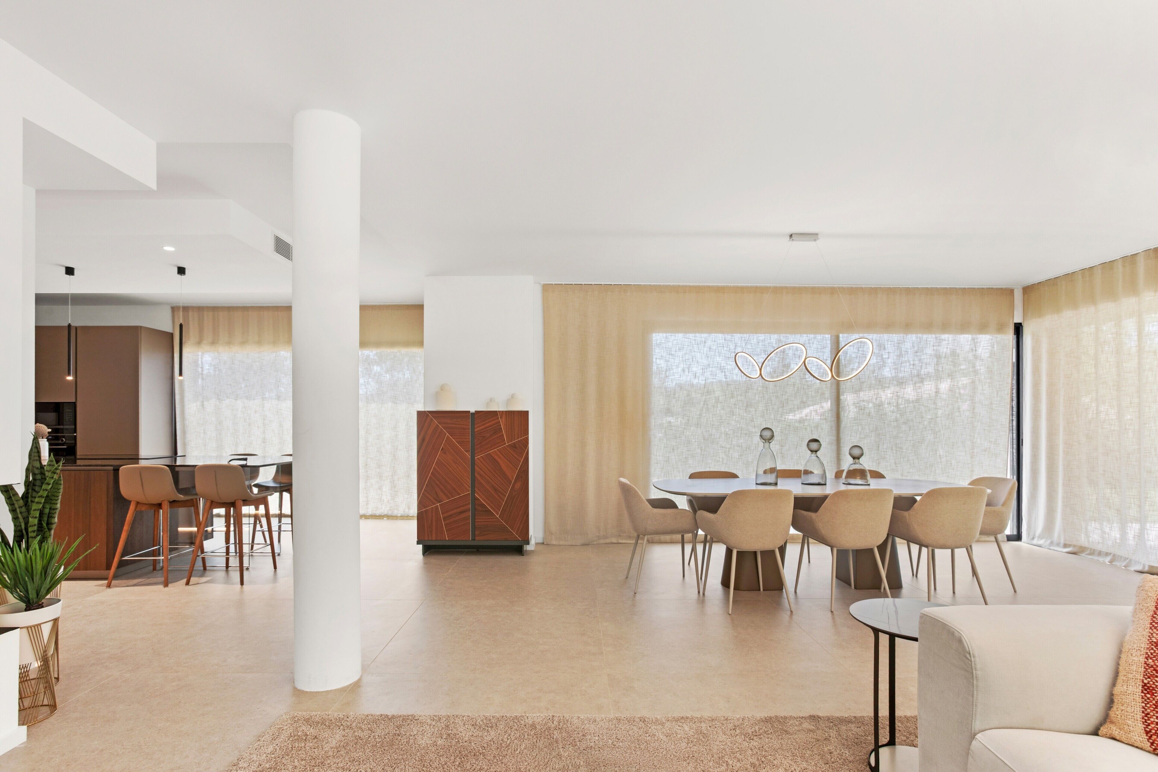 A modern living space with a dining area, kitchen, and seating area.