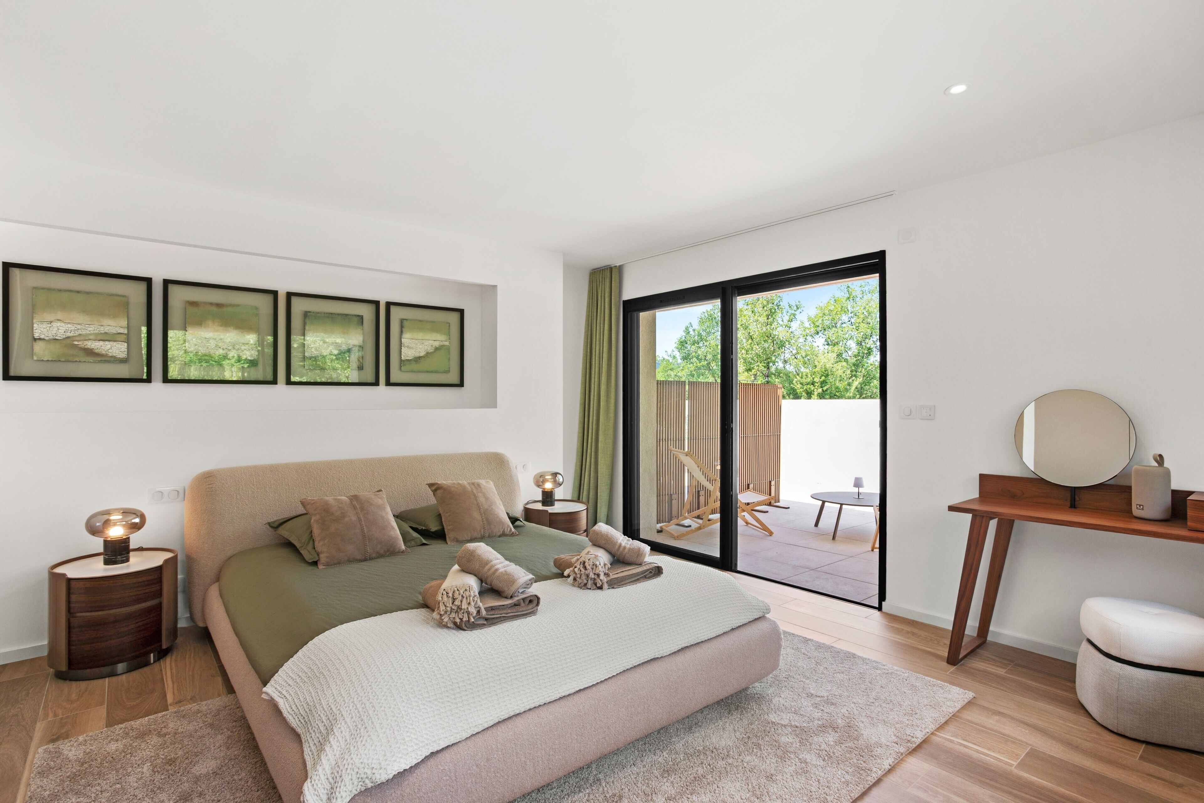 Een moderne slaapkamer met een groot bed, een bureau en uitzicht op de omgeving.