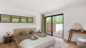 Een moderne slaapkamer met een groot bed, een bureau en uitzicht op de omgeving.