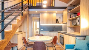 Una cucina moderna con mobili in legno, forno integrato e microonde.