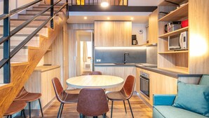 A modern kitchen with a round dining table, chairs, and a staircase. - Family Alpine Base for 5 in Doucy (La Léchère)