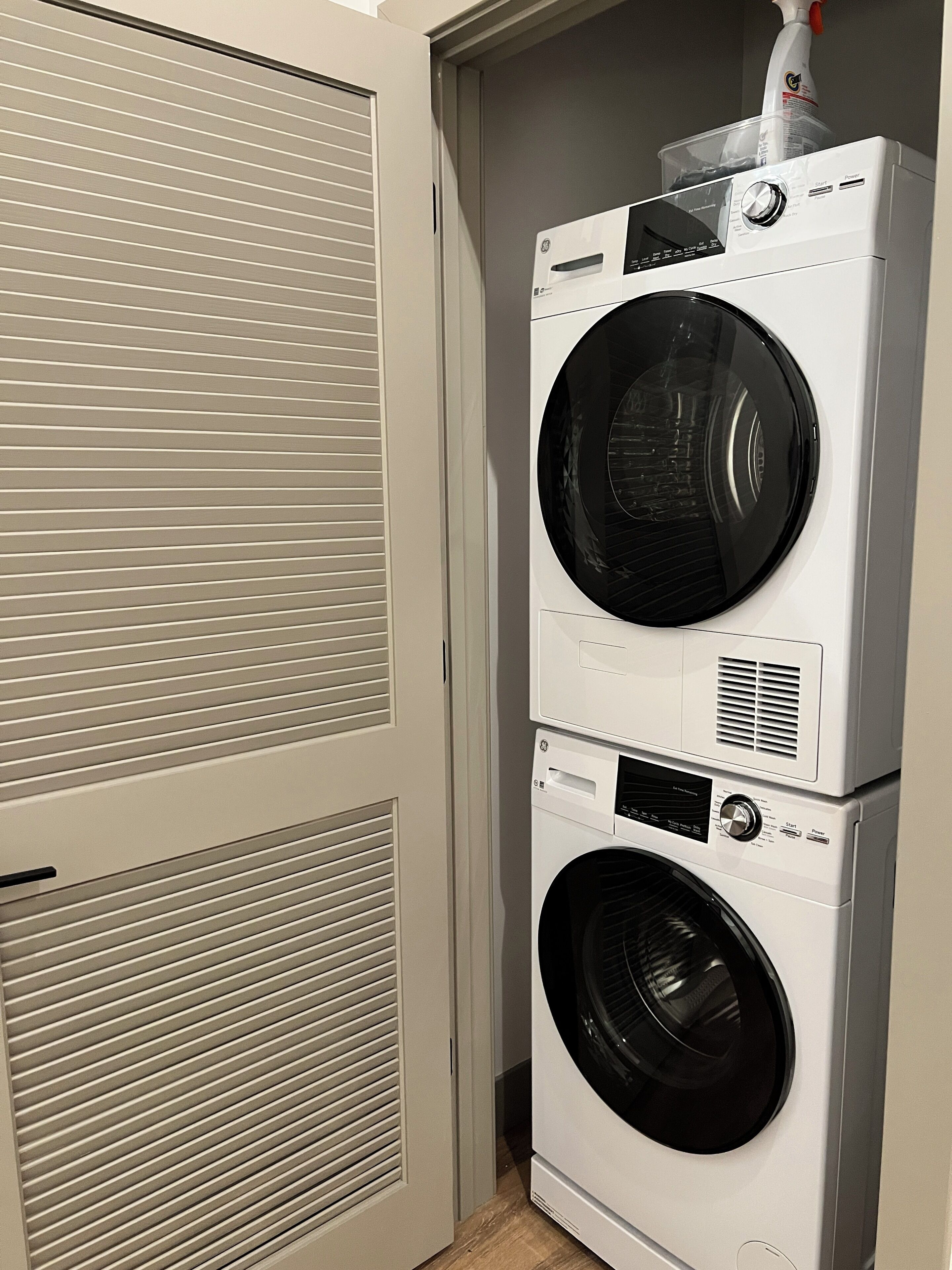 A stacked washer and dryer unit in a utility room.