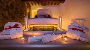 A spa room with a massage table, towels, and candles. - Azienda agricola la camporena  (Greve in Chianti)