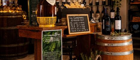 A wine display with bottles, a large bottle of olive oil, and a wooden crate labeled 'nutella'.
