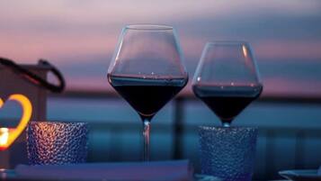 Duas taças de vinho sobre uma mesa, com fundo desfocado.