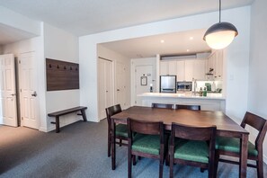 A modern kitchen with white cabinets, a built-in microwave, and a stainless steel refrigerator.