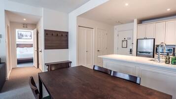 A modern kitchen with white cabinetry, a built-in microwave, and a stainless steel refrigerator.