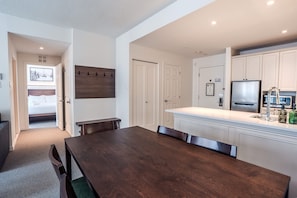 A modern kitchen with white cabinetry, a built-in microwave, and a stainless steel refrigerator.