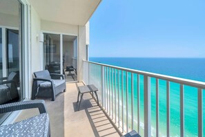 A balcony with outdoor furniture, a glass door leading inside, and a view of the ocean. - Tidewater 2405 (Panama City Beach)