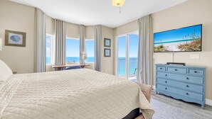 Een slaapkamer met een groot bed, een dressoir, een bureau en een televisie.