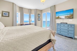 A bedroom with a large bed, a dresser, a desk, and a TV. - Tidewater 2405 (Panama City Beach)