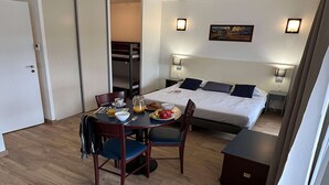 A hotel room with a bed, bedside tables, a dining table with chairs, and a small desk. - 4-persons Studio With Balcony (Bolquere)
