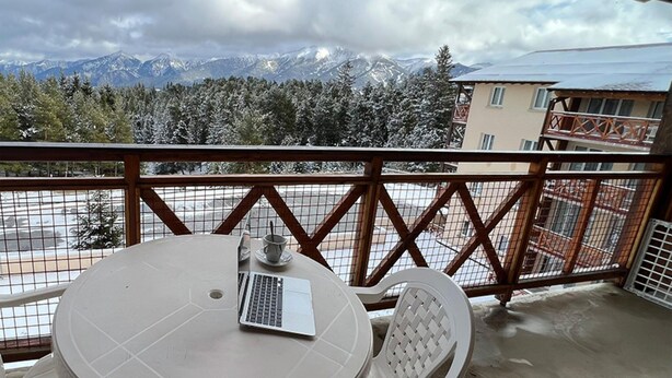 A balcony with a table, a chair, and a laptop. - Mountain-view 6-persons Apartment (Bolquere)