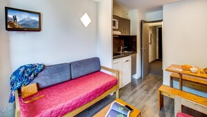 A compact living space with a sofa, a small table, a kitchen area, and a dining table. - High-altitude Home for 4 (Garin)