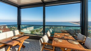 A balcony with a view of the sea, wooden furniture, and a patterned floor. - Modern Sea View Penthouse with Private Terrace – 20 Min to IST (Karaburun)