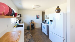 A compact kitchen with a stove, refrigerator, and wooden counter. - Sweeping Desert & Mountain Views Near Downtown Joshua Tree & JT National Park (Joshua Tree)