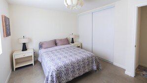 A bedroom with a bed, two bedside tables with lamps, a ceiling light fixture, and a closet. - Sweeping Desert & Mountain Views Near Downtown Joshua Tree & JT National Park (Joshua Tree)