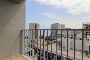 A balcony with a view of a cityscape, including high-rise buildings and a clear sky. - w* | Stylish 2BR w/ Balcony & View in Miraflores (Miraflores)