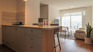 Una cocina moderna con una isla grande, un comedor con vistas y una sala de estar con una planta.