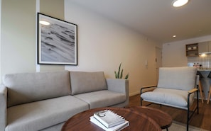 A living room with a sofa, armchair, and a coffee table with books. - w* | Light-Filled 2BR w/ Balcony in Miraflores (Miraflores)