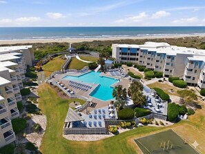 Un resort con piscina, vista a la playa y varias edificaciones.
