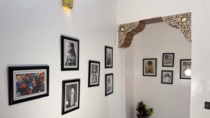 Un pasillo con cuadros en las paredes, una planta en maceta y un arco decorativo.