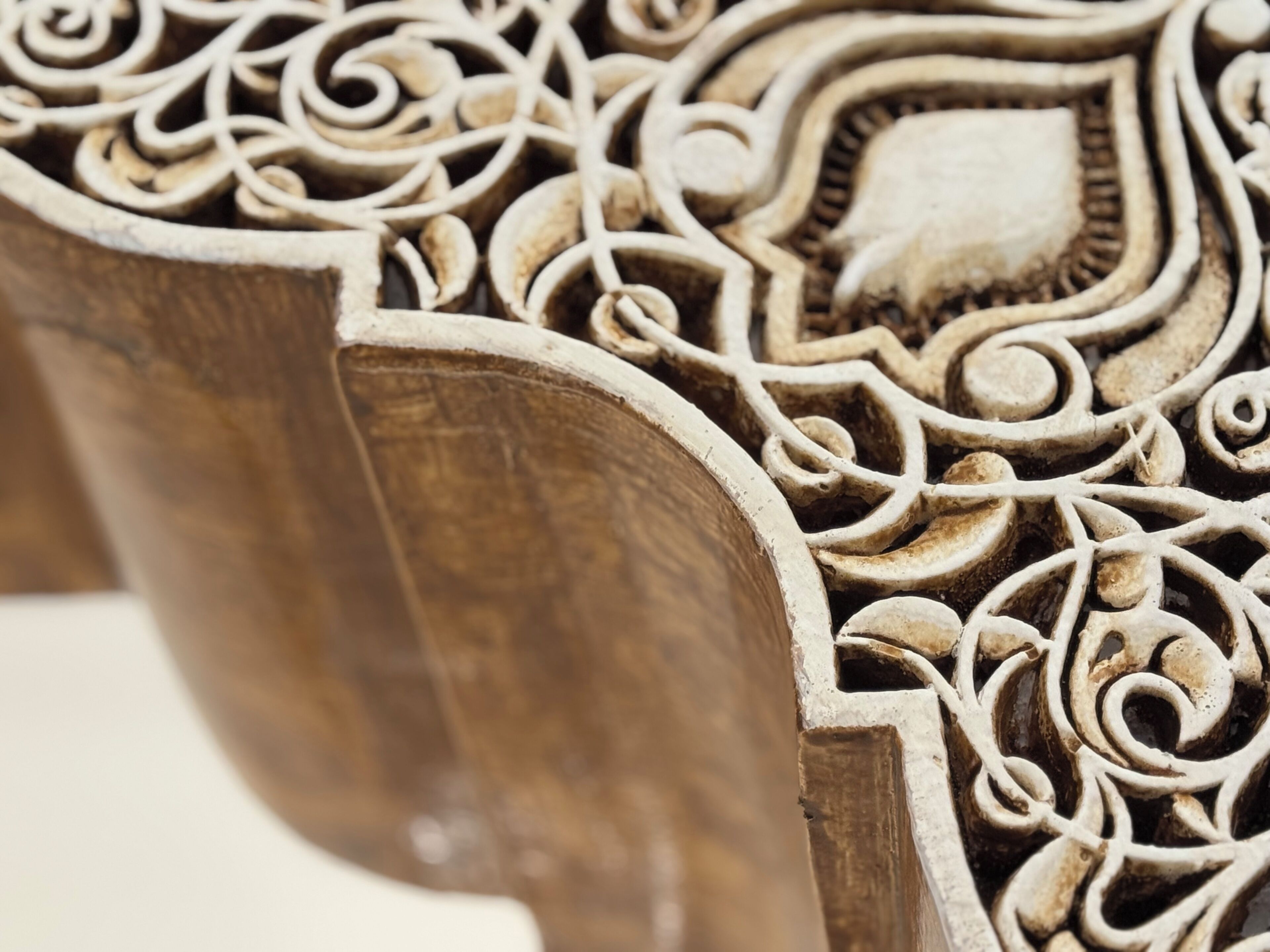 A close-up of a wooden chair with intricate carvings.