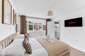 A bedroom with a bed, a TV, and a window. - The Wiltshire •  Detached 5BR House • Driveway Parking • Work Space • Smart TVs • By Yoko Property (Milton Keynes)