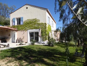 Ein zweistöckiges Haus mit Garten, Terrasse und Garage.